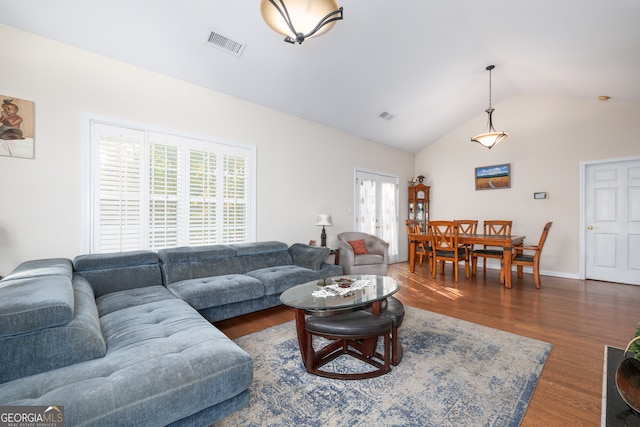 living room with lofted ceiling, plenty of natural light, and dark hardwood / wood-style flooring