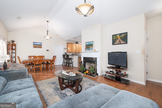 living room featuring a premium fireplace, vaulted ceiling, and dark hardwood / wood-style flooring