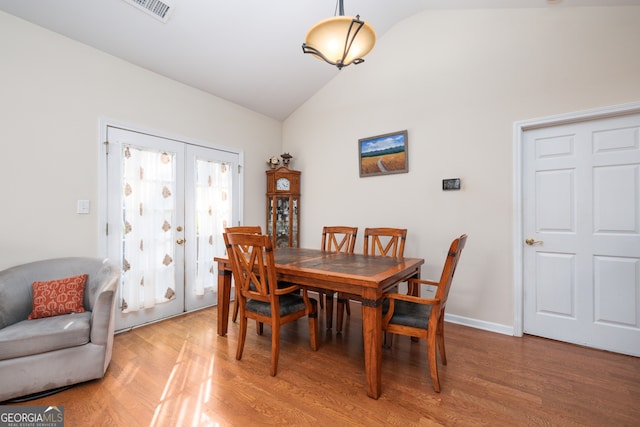 dining area featuring lofted ceiling and wood-type flooring