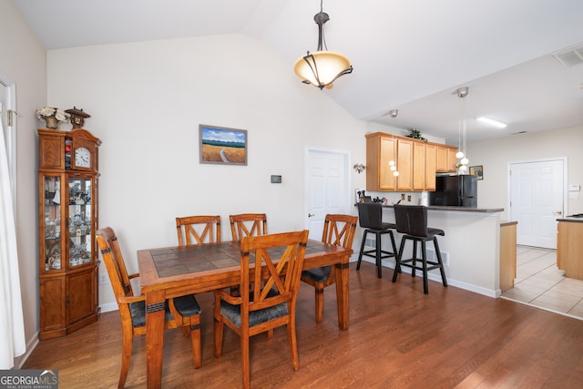 dining area with lofted ceiling and light wood-type flooring