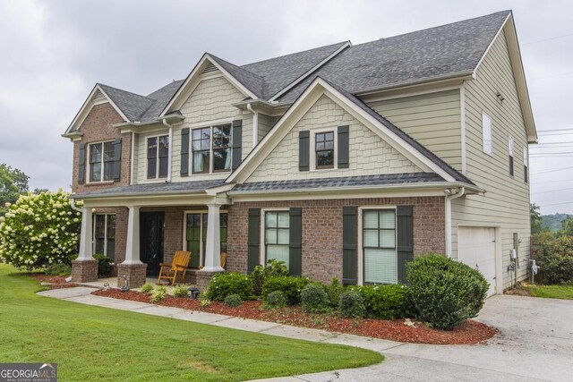 craftsman-style home with a front yard, a porch, and a garage