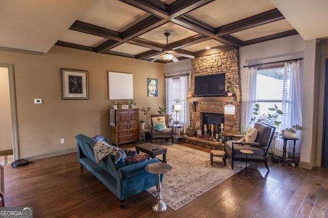 living room with beamed ceiling, dark wood-type flooring, a stone fireplace, and coffered ceiling