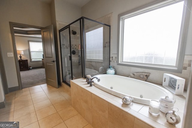 bathroom with a jetted tub, a shower stall, and tile patterned floors