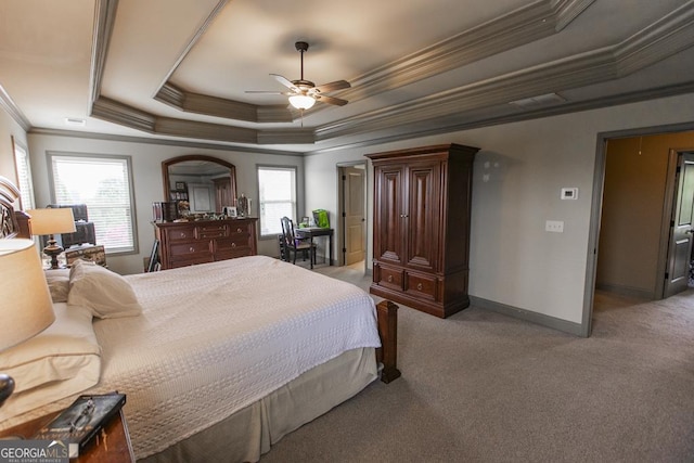 carpeted bedroom with ceiling fan, a raised ceiling, crown molding, and multiple windows