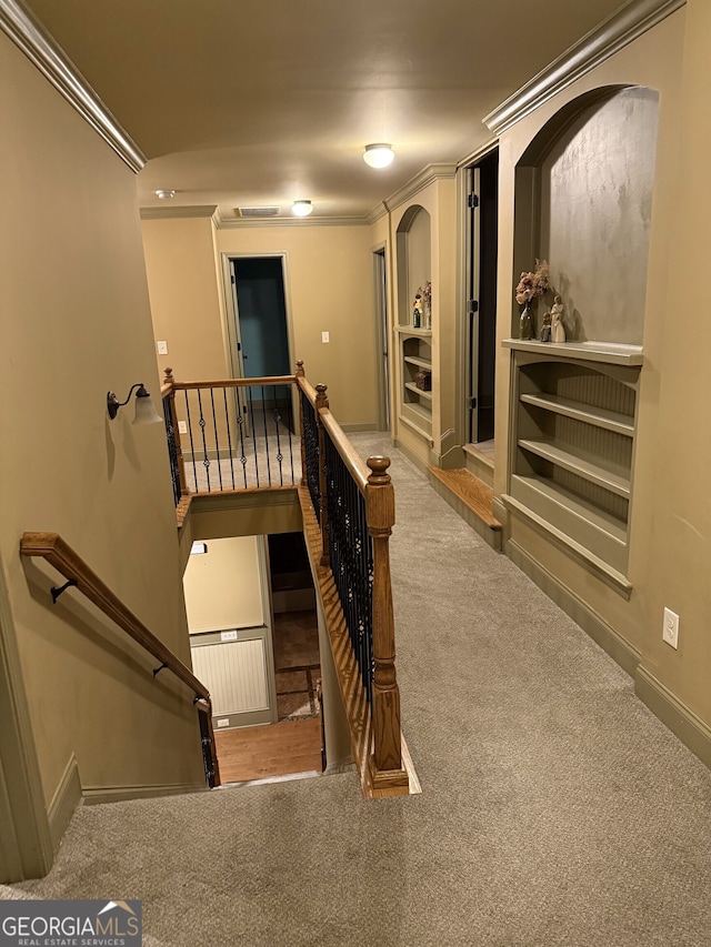 interior space featuring carpet floors, ornamental molding, visible vents, and baseboards