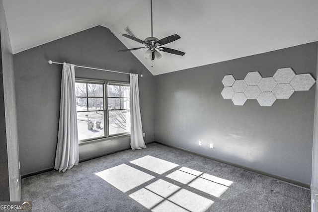 carpeted spare room featuring lofted ceiling, baseboards, and a ceiling fan