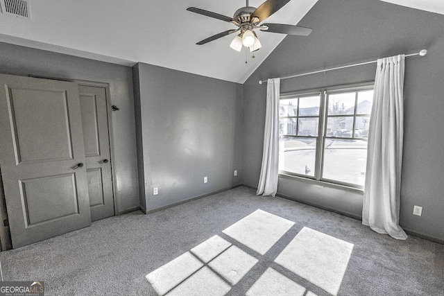 unfurnished bedroom featuring visible vents, baseboards, a ceiling fan, carpet, and high vaulted ceiling