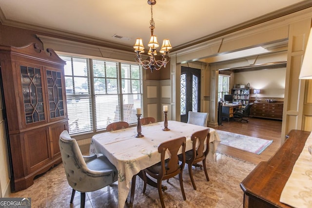 dining space featuring a notable chandelier, ornamental molding, and light hardwood / wood-style flooring