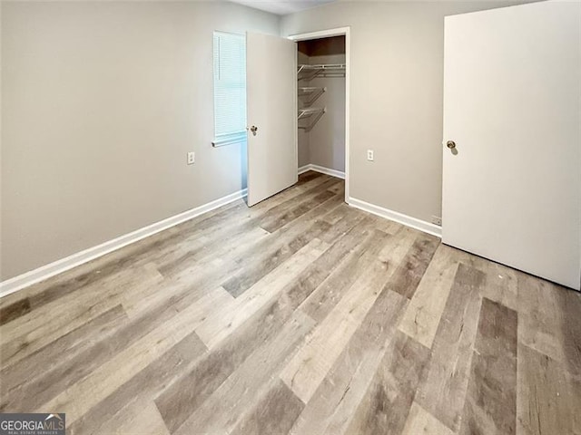 unfurnished bedroom with a closet and light wood-type flooring