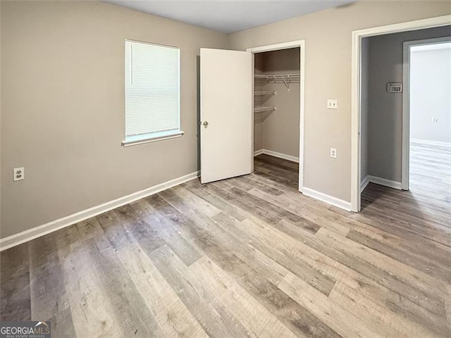 unfurnished bedroom featuring light hardwood / wood-style flooring and a closet