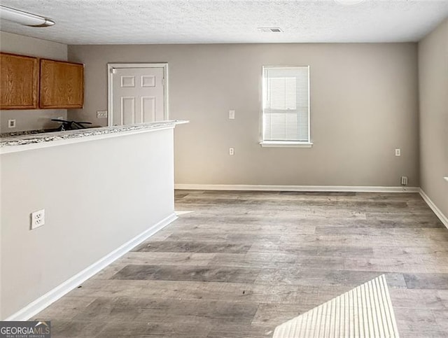 interior space with a textured ceiling and light wood-type flooring