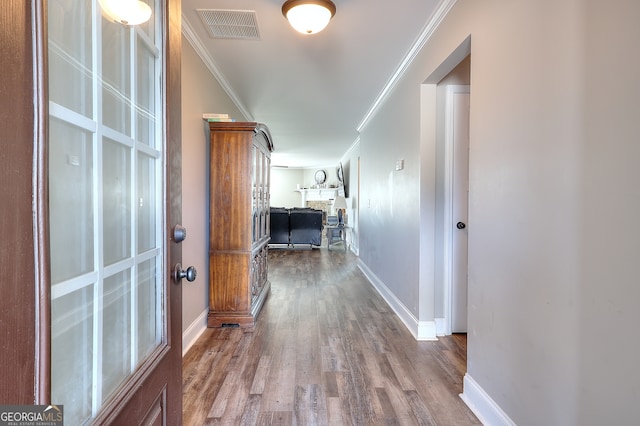 hall with ornamental molding and wood-type flooring