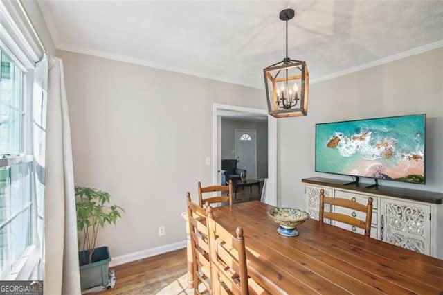 dining area featuring a chandelier, crown molding, and wood-type flooring