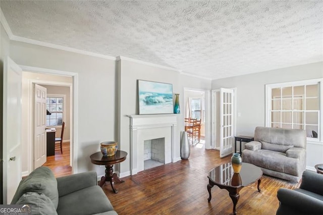 living room with a textured ceiling, ornamental molding, and hardwood / wood-style floors