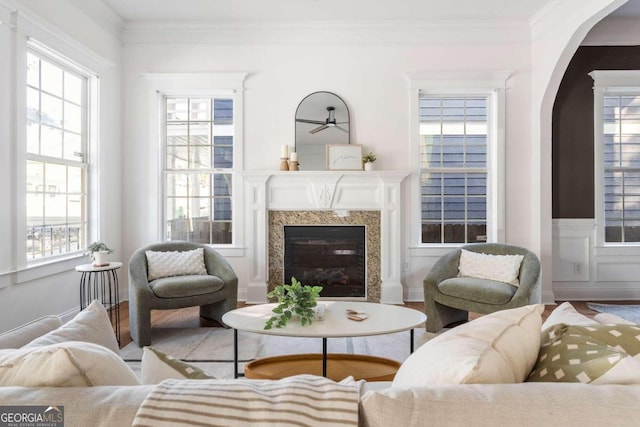 living room featuring crown molding, a wealth of natural light, a fireplace, and hardwood / wood-style floors