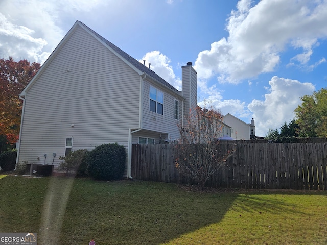 view of property exterior featuring central AC and a yard