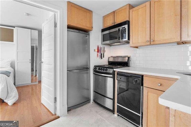 kitchen featuring backsplash, appliances with stainless steel finishes, light hardwood / wood-style flooring, and light brown cabinetry