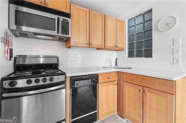 kitchen with backsplash, appliances with stainless steel finishes, sink, and light brown cabinetry