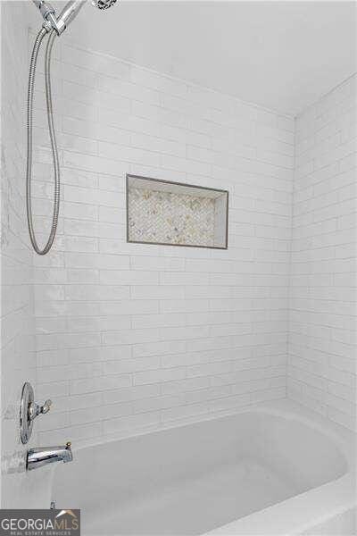 bathroom with tiled shower / bath combo