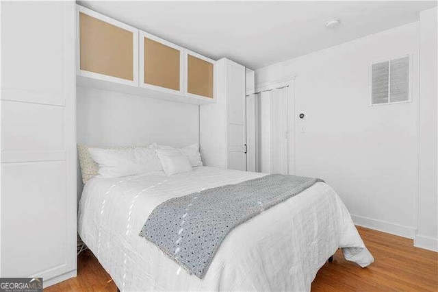 bedroom with hardwood / wood-style flooring and a closet