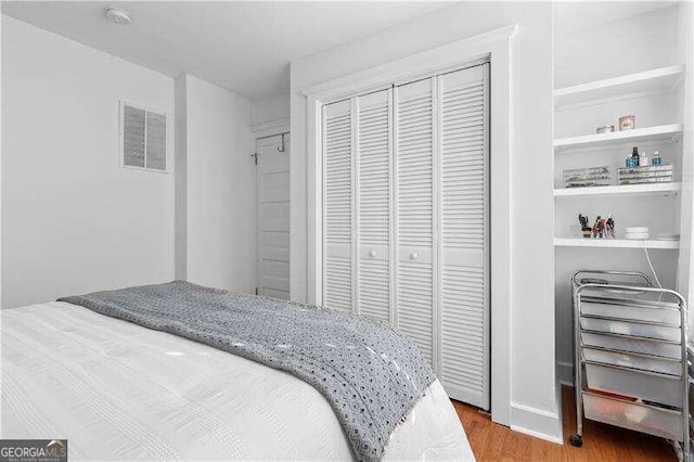 bedroom with wood-type flooring and a closet