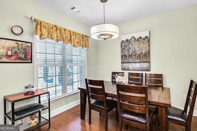 dining area featuring wood finished floors, visible vents, and baseboards