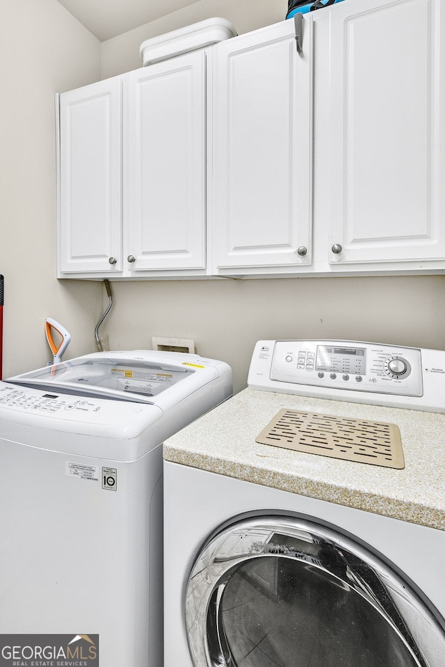 washroom featuring washer and dryer and cabinet space