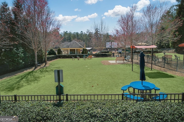 view of home's community with fence and a yard