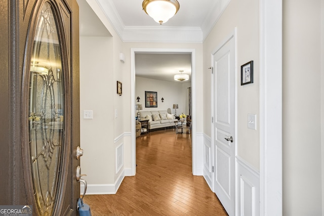 entrance foyer with ornamental molding and wood finished floors