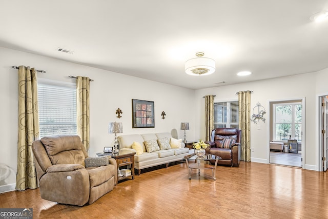 living area with visible vents, baseboards, and wood finished floors