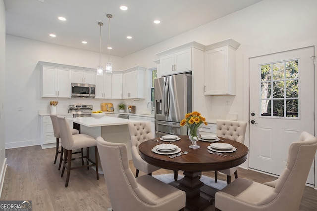 kitchen with white cabinetry, appliances with stainless steel finishes, sink, and hanging light fixtures