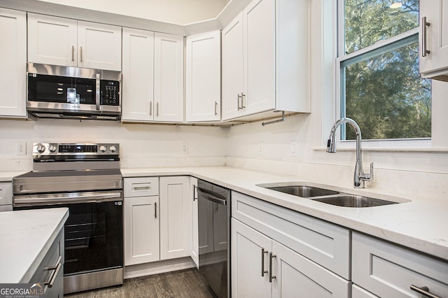 kitchen featuring white cabinetry, stainless steel appliances, sink, and light stone counters