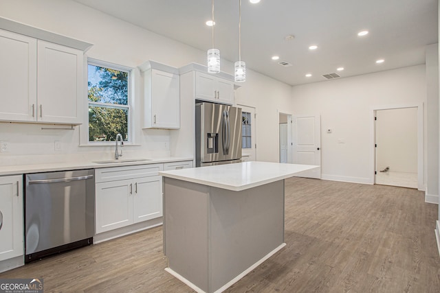 kitchen featuring white cabinets, light hardwood / wood-style floors, appliances with stainless steel finishes, and sink