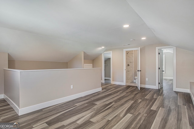 additional living space with dark hardwood / wood-style flooring and vaulted ceiling