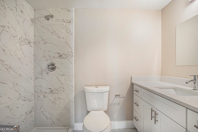 bathroom featuring vanity, toilet, and tiled shower