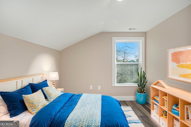 bedroom with dark wood-type flooring and lofted ceiling