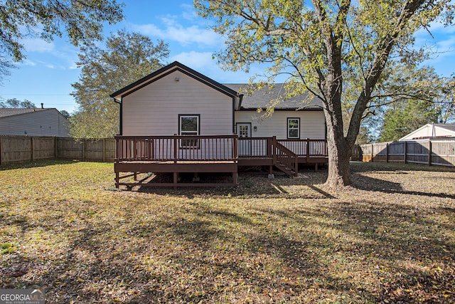 back of house featuring a lawn and a wooden deck