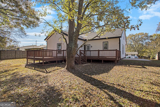 back of property featuring a deck and a yard