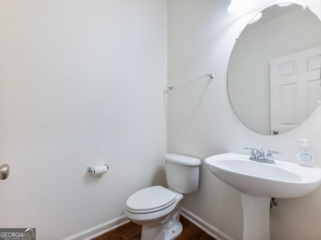 bathroom with toilet and hardwood / wood-style floors