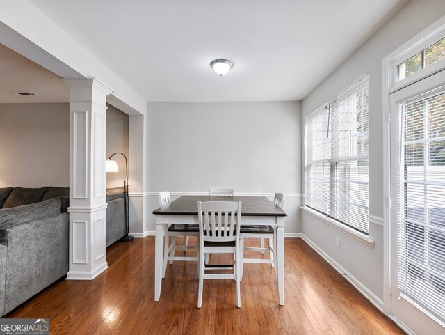 dining space with decorative columns and dark hardwood / wood-style floors