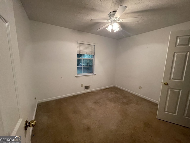 spare room featuring a textured ceiling, carpet floors, visible vents, baseboards, and a ceiling fan