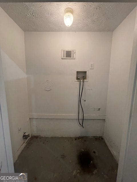 washroom featuring a textured ceiling, laundry area, hookup for a washing machine, and visible vents