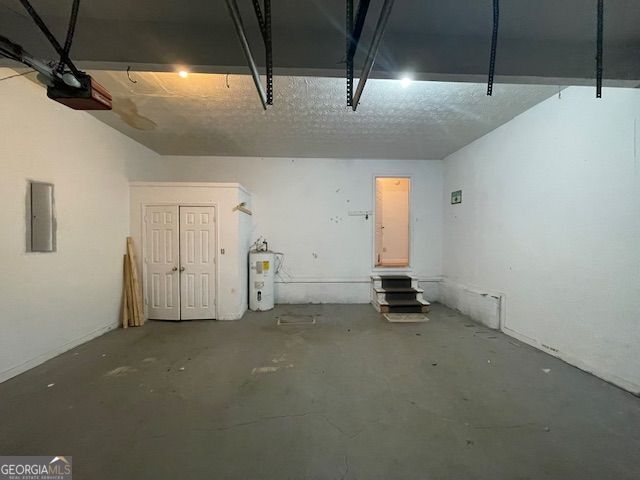 garage featuring a garage door opener, electric panel, and electric water heater