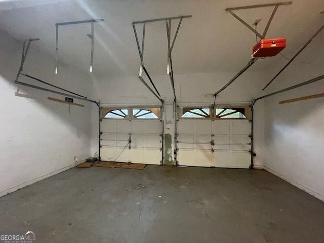 garage with a garage door opener and baseboards