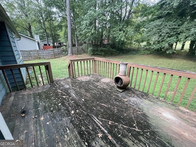 wooden deck with fence and a lawn