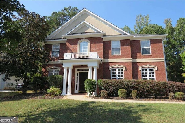 view of front of home with a balcony and a front lawn