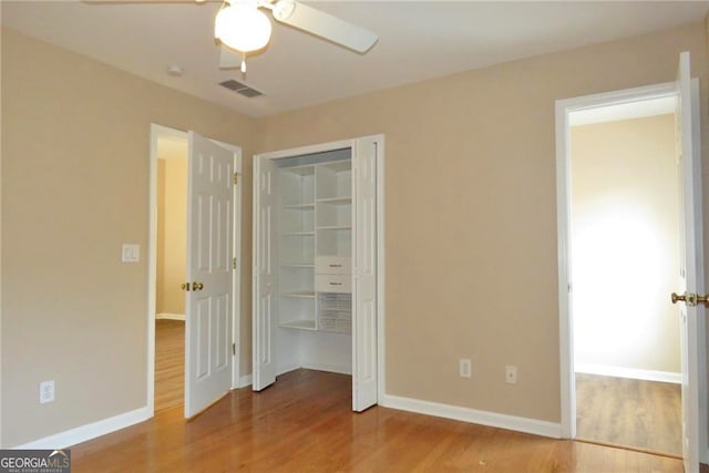 unfurnished bedroom with hardwood / wood-style flooring, a closet, and ceiling fan