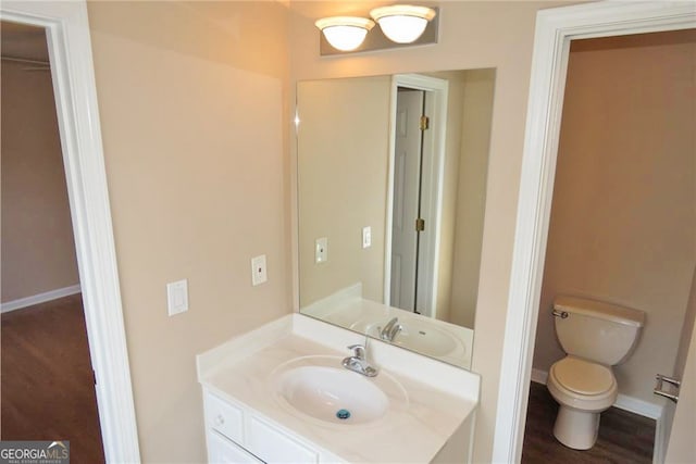 bathroom with vanity, hardwood / wood-style flooring, and toilet