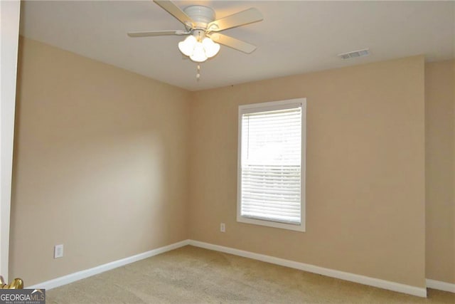 carpeted spare room with ceiling fan