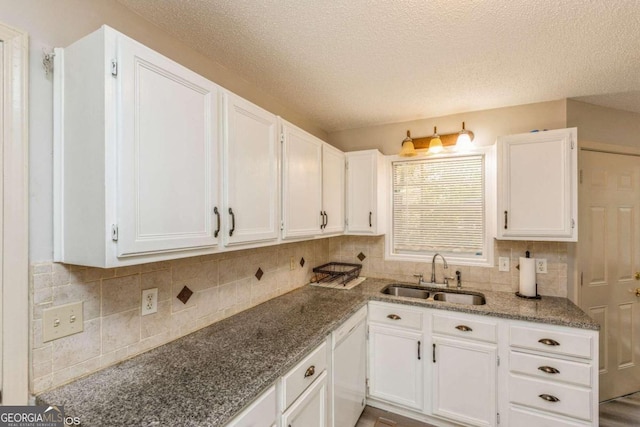 kitchen with dishwasher, decorative backsplash, sink, and white cabinets